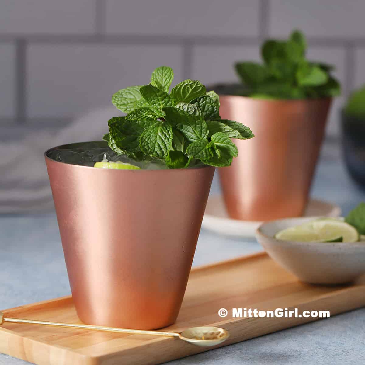 Copper cups of non-alcoholic Moscow mule mocktails, garnished with mint.