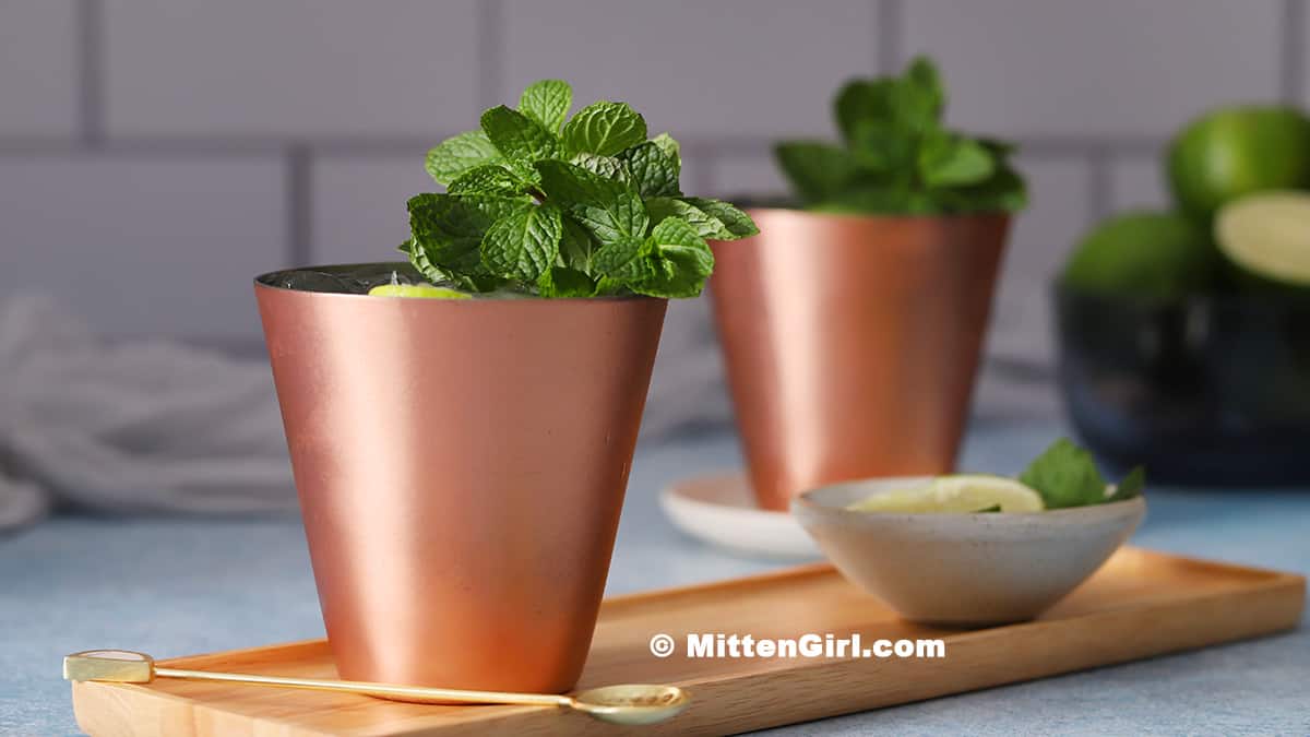 Copper cups filled with moscow mule mocktails and garnished with mint.