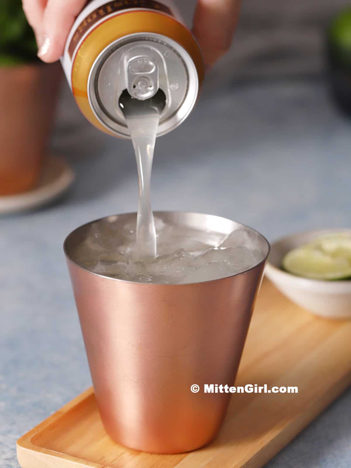 Ginger beer being poured into a copper cup.