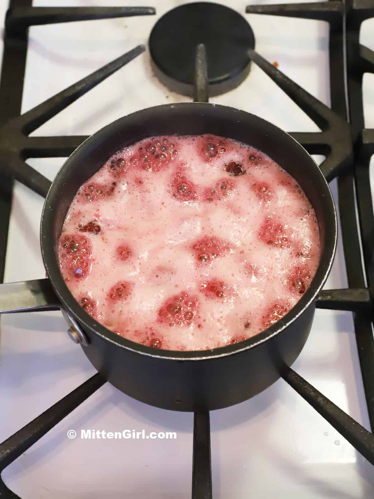 Blackberry syrup foaming up on the stove.