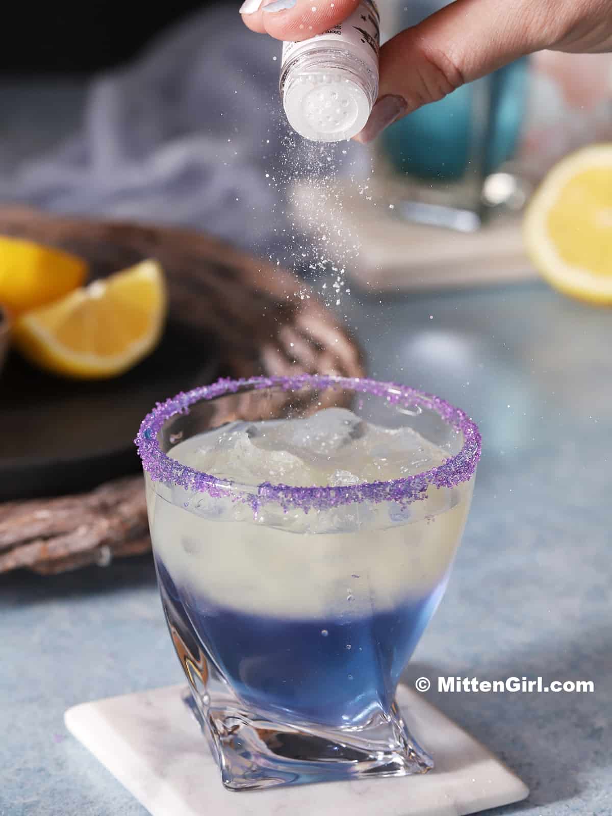 Edible glitter being dusted on a finished unicorn drink.