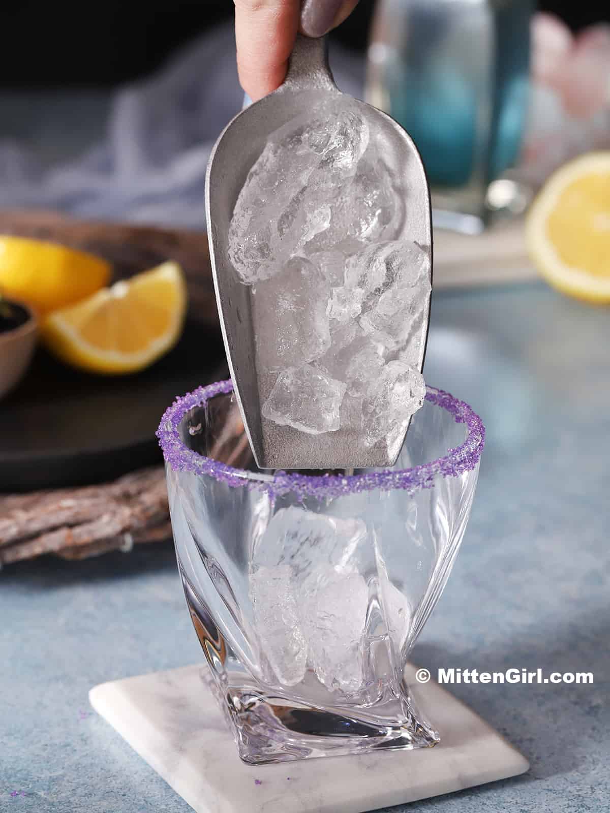 Ice being poured into a rocks glass.