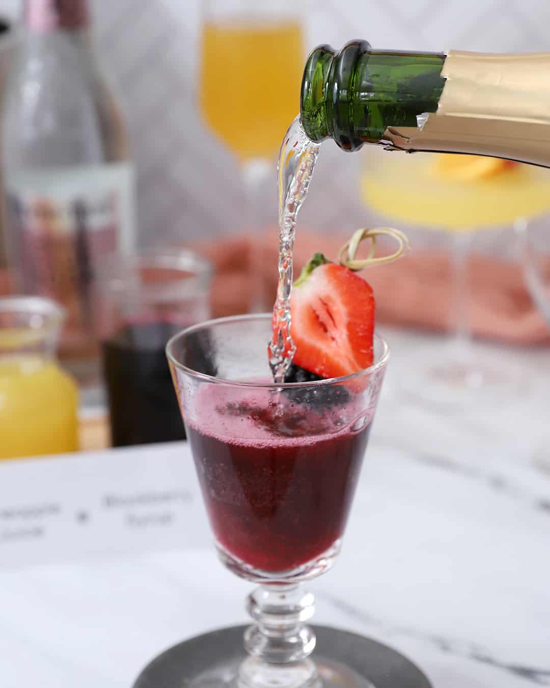 Prosecco being poured into a glass with syrup.