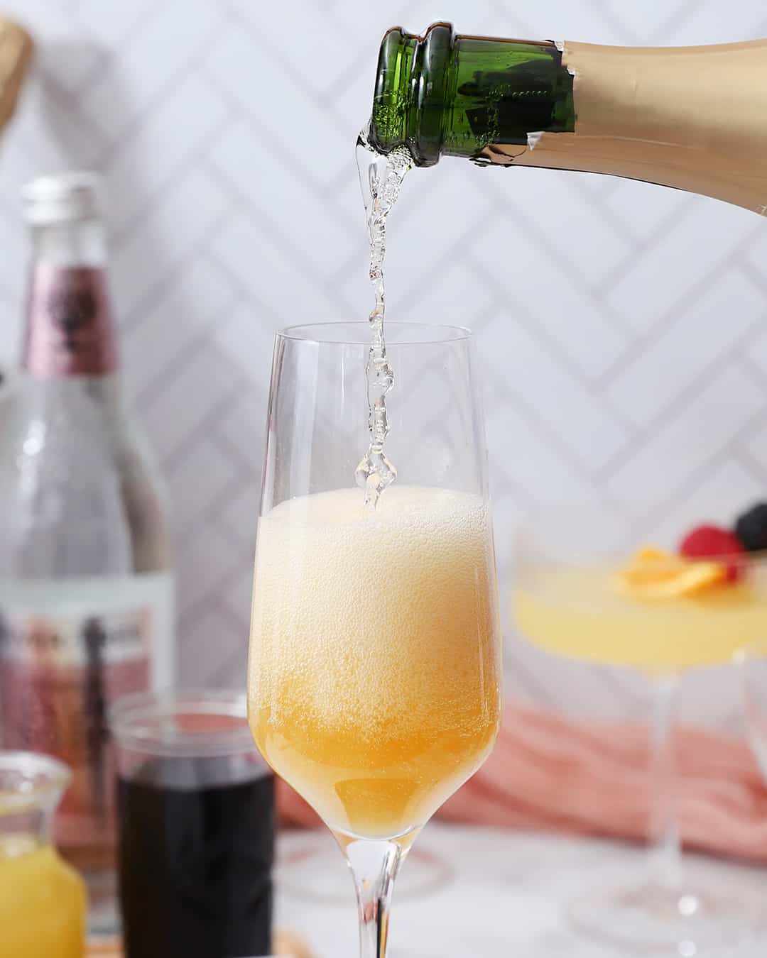 Champagne being poured into a glass with juice.