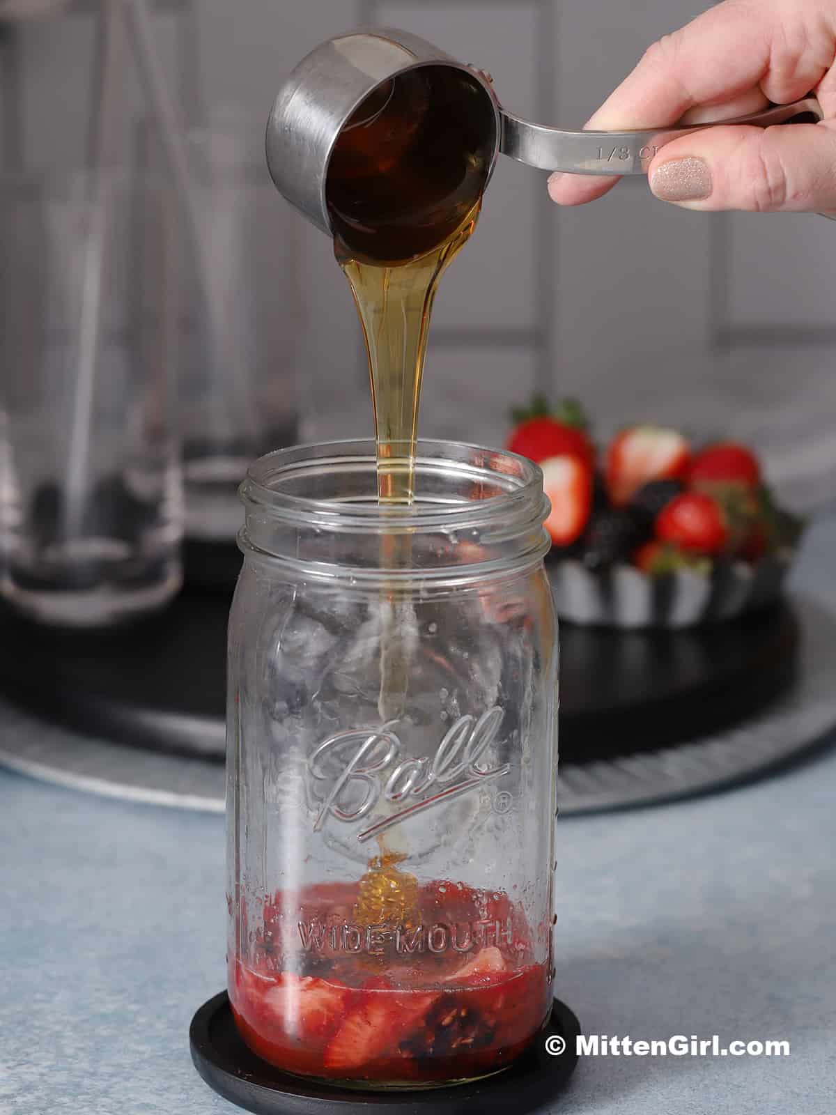 Honey being poured into a quart jar.