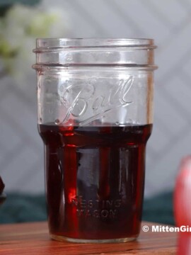 A mason jar of homemade cherry vodka.