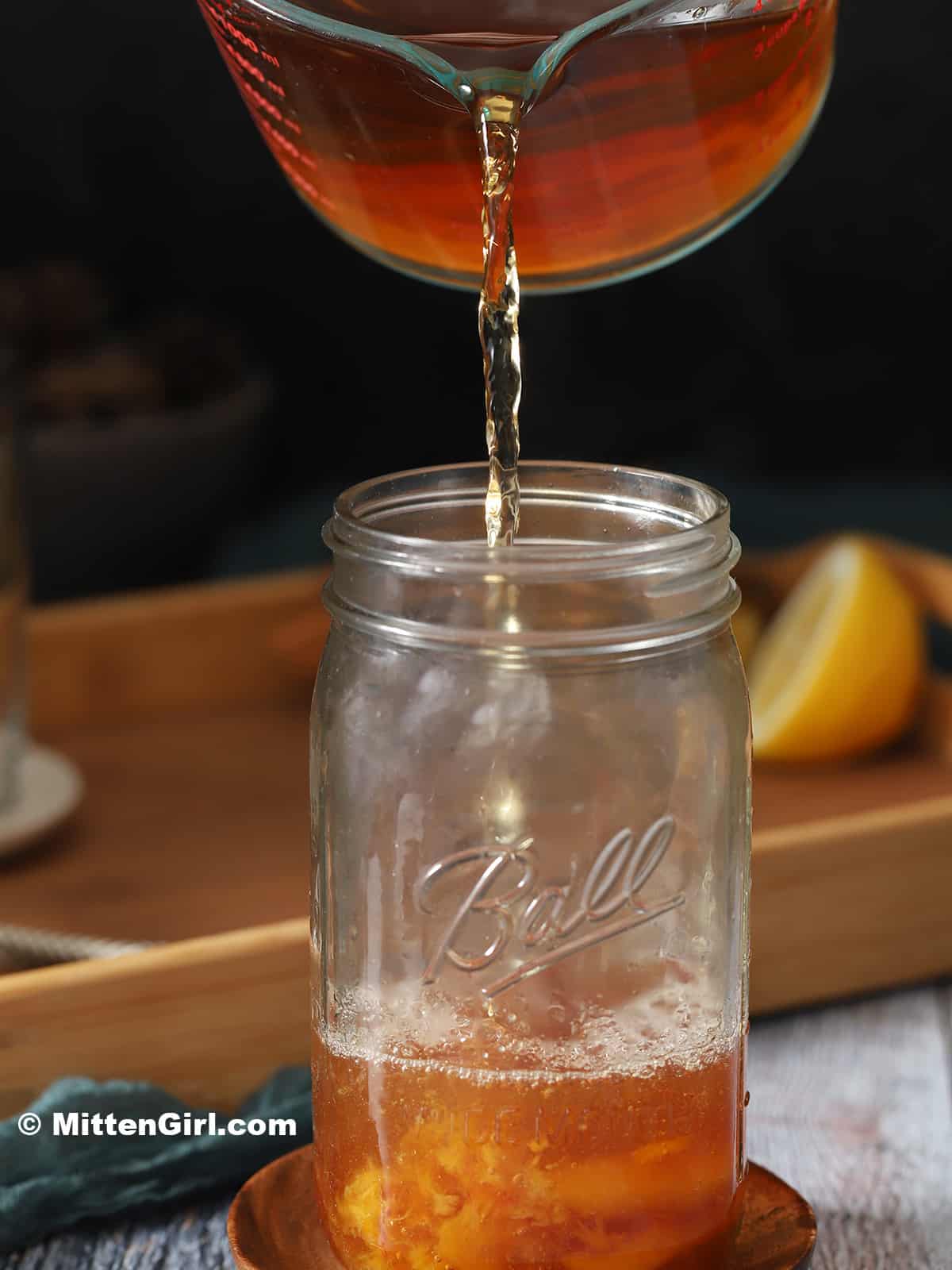 Hot tea being poured into a mason jar.