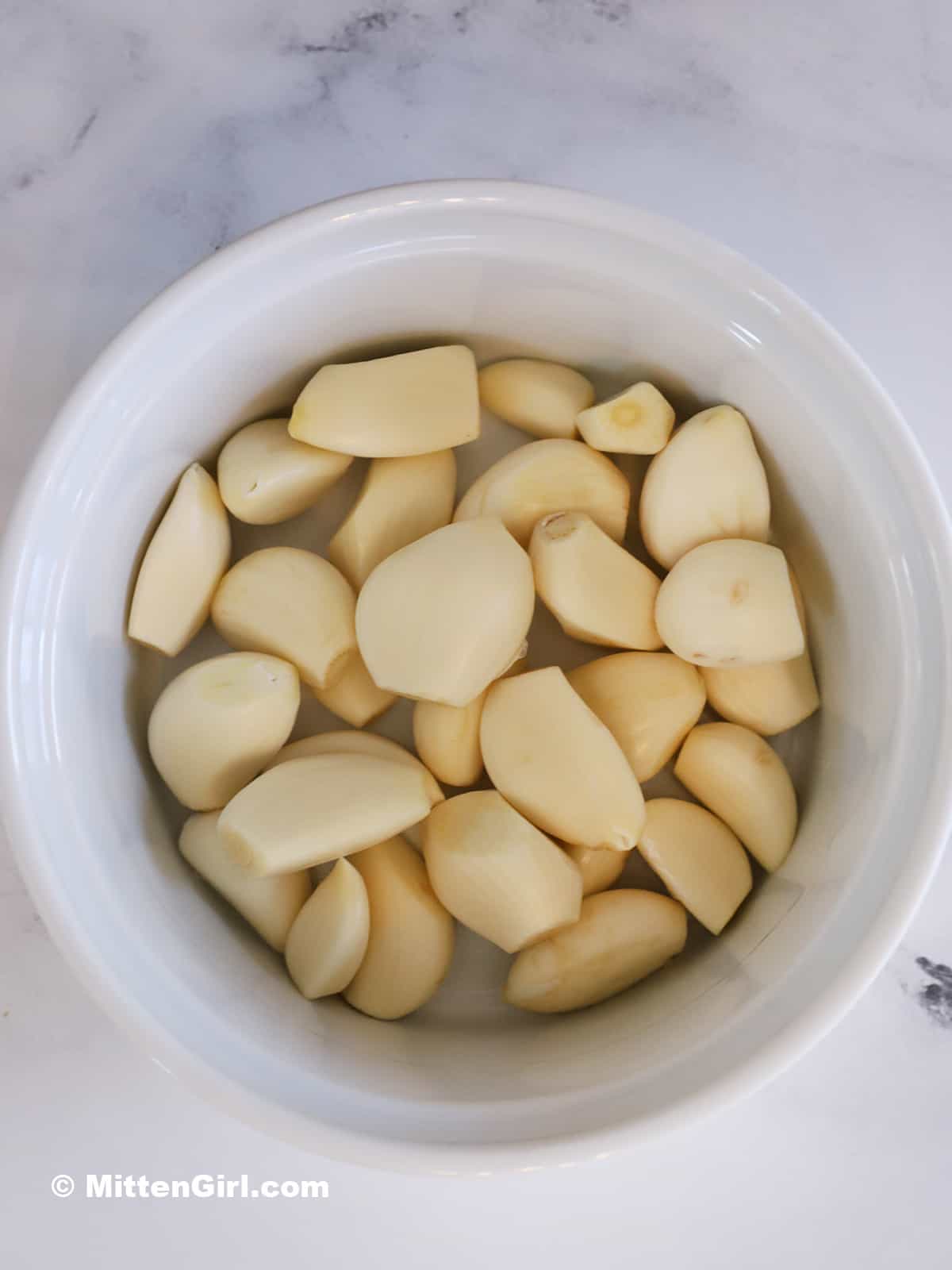 Peeled garlic in a baking dish.