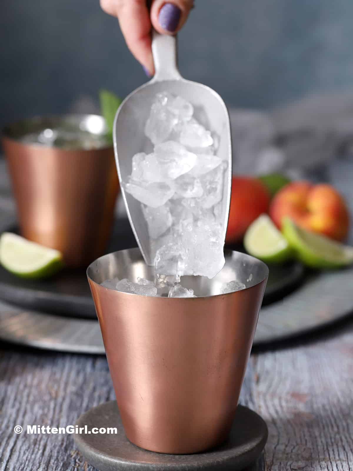 Ice being poured into a copper cup. 