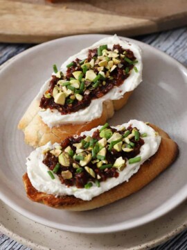 Two pieces of feta bruschetta on a plate.
