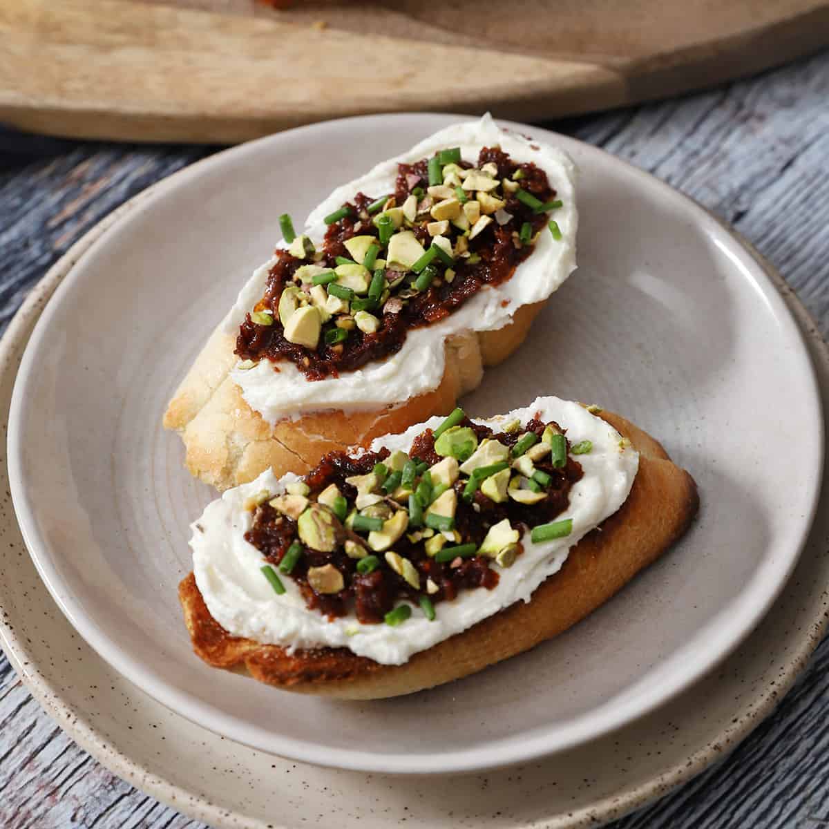 Two pieces of feta bruschetta on a plate.