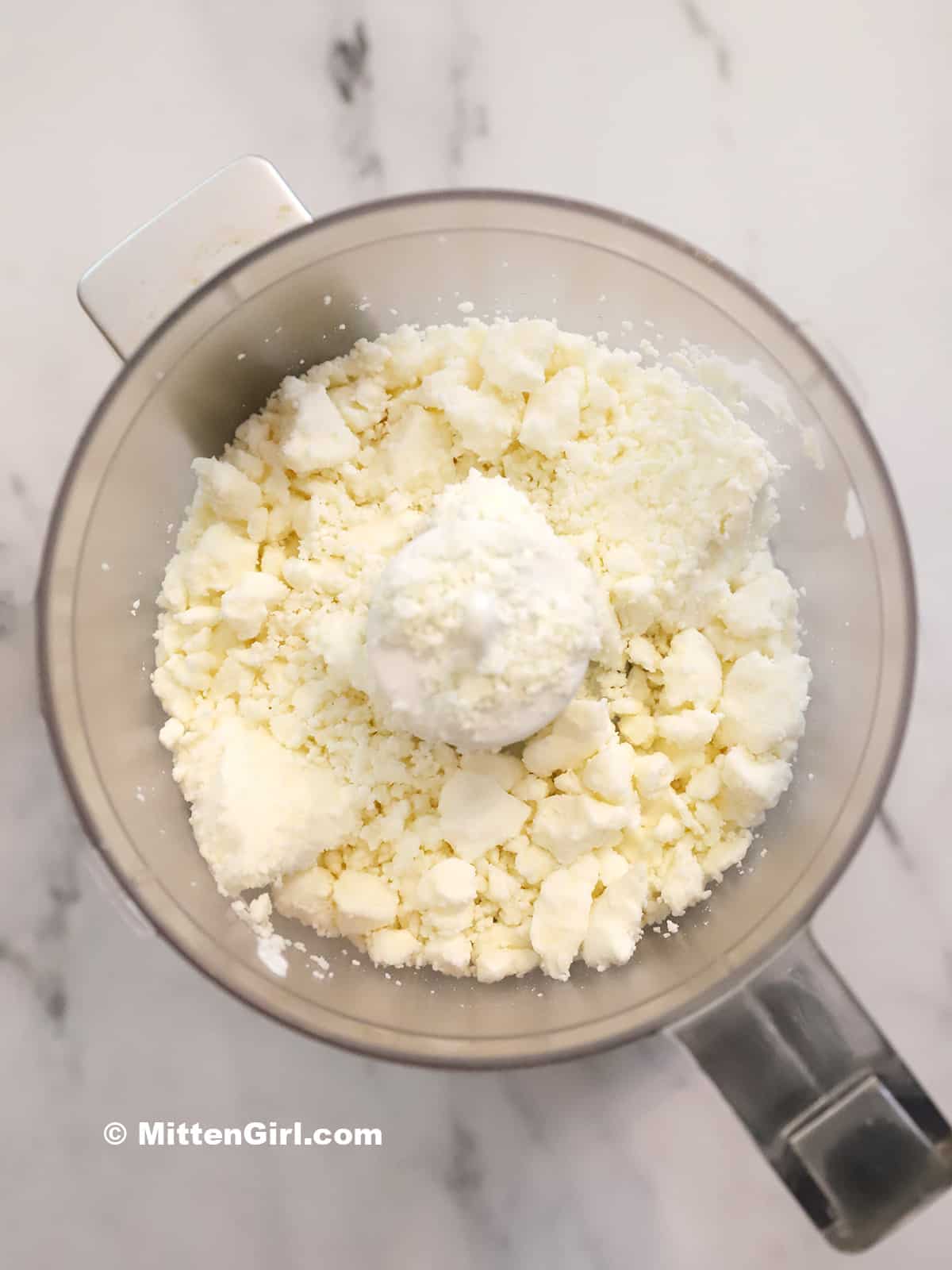 Crumbled feta cheese and cream cheese in a food processor. 