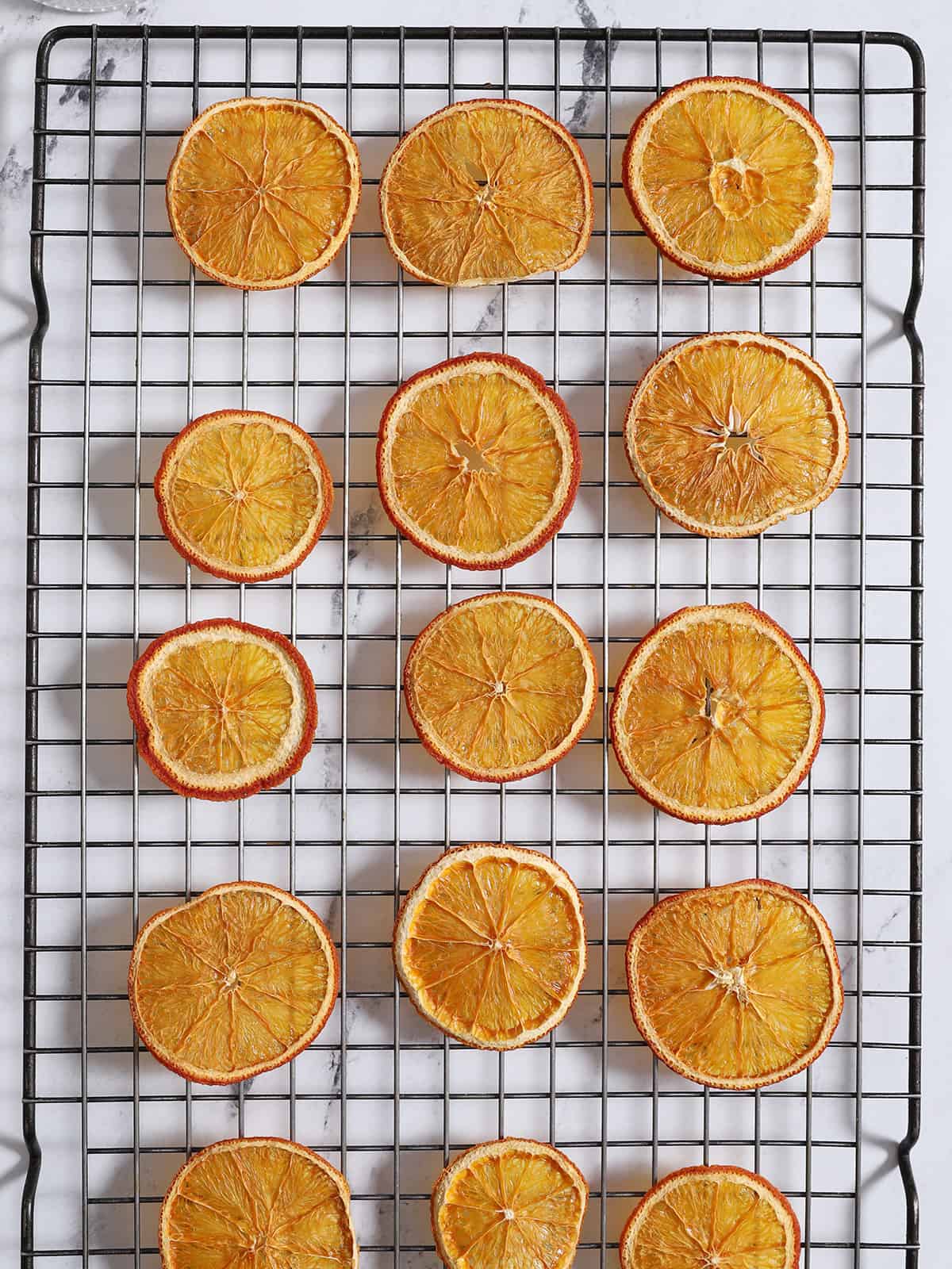 A wire rack filled with dried orange slices. 