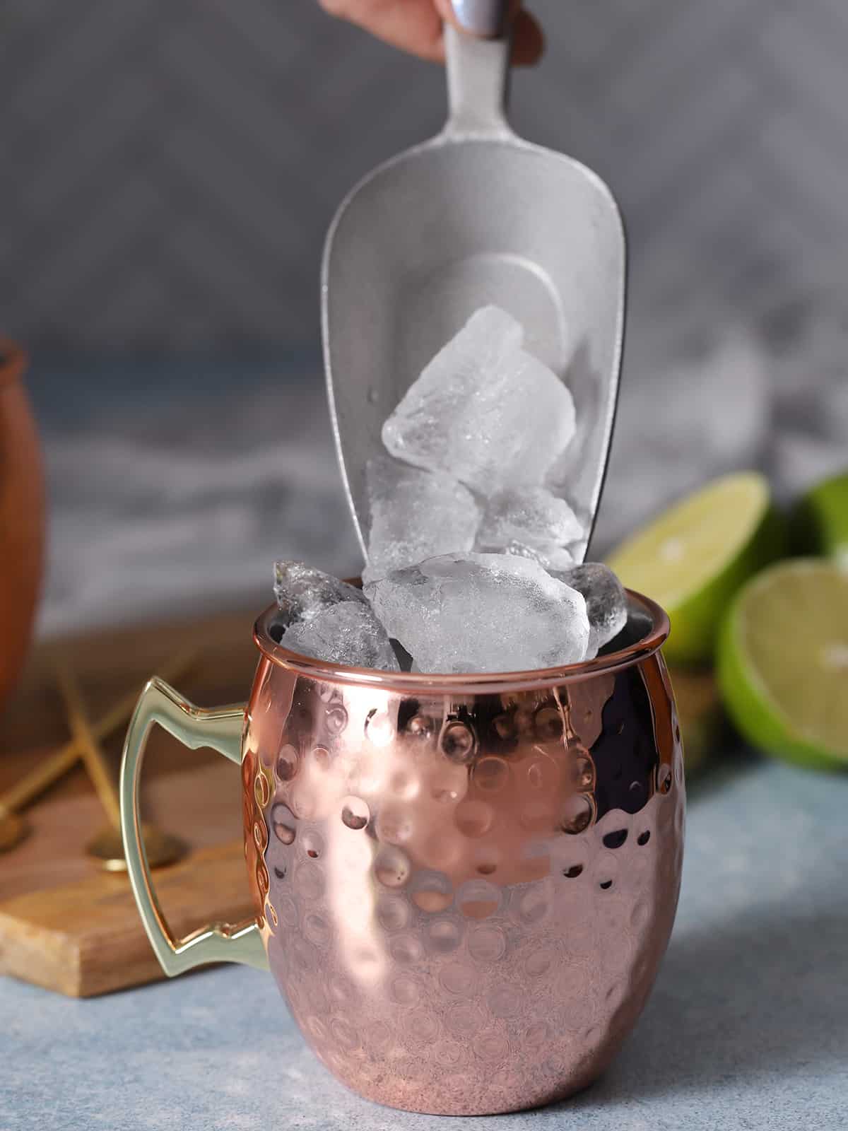 Ice being poured into a copper cup.