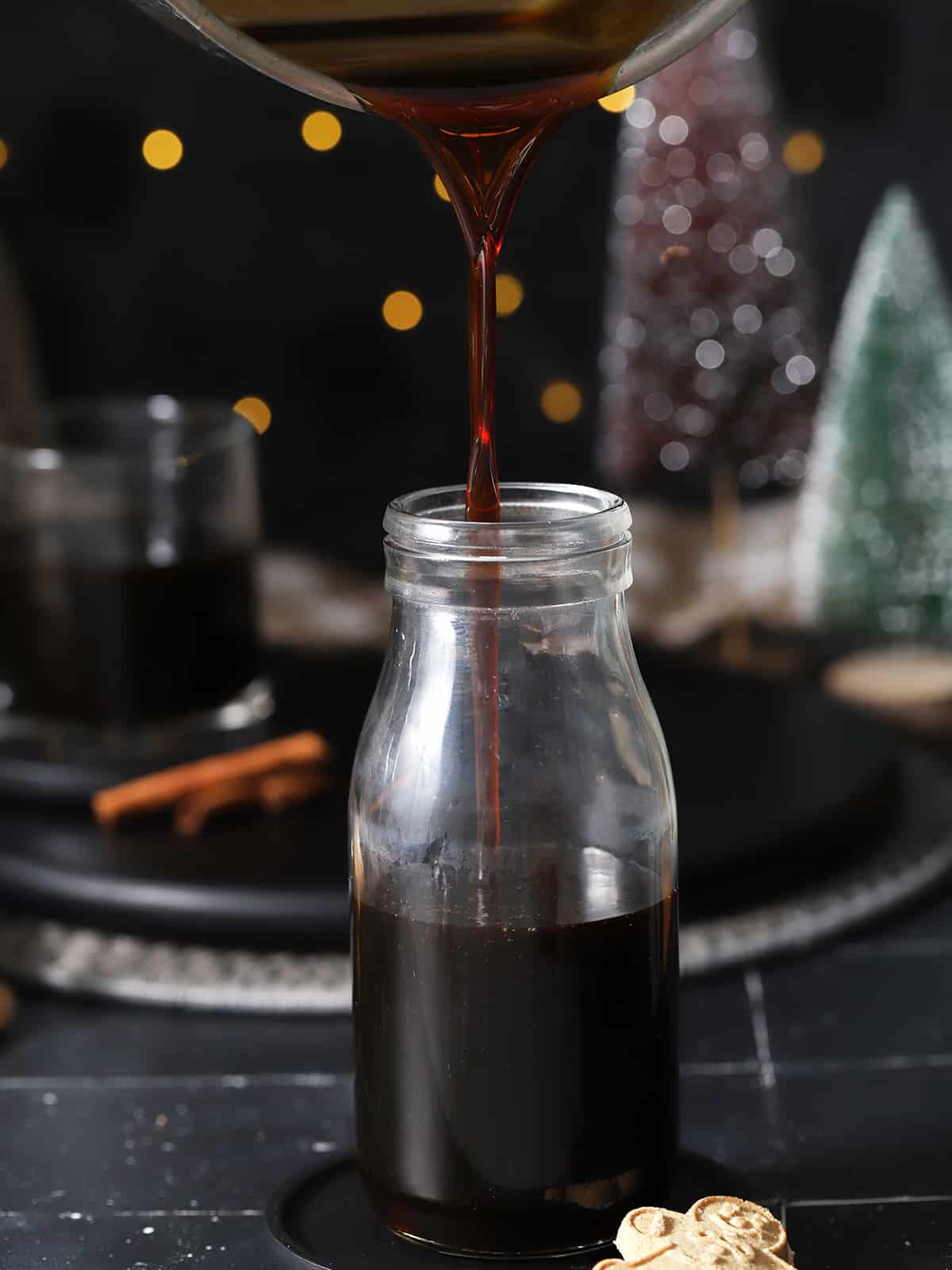 Gingerbread syrup being poured from a pot into a glass bottle. 