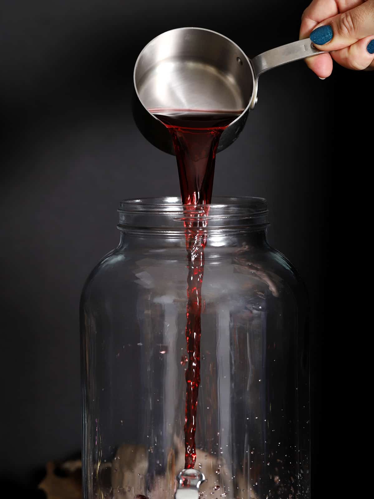Grape juice bring poured into a large pitcher. 