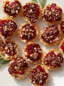 A plate of brie cheese and cranberry bites.