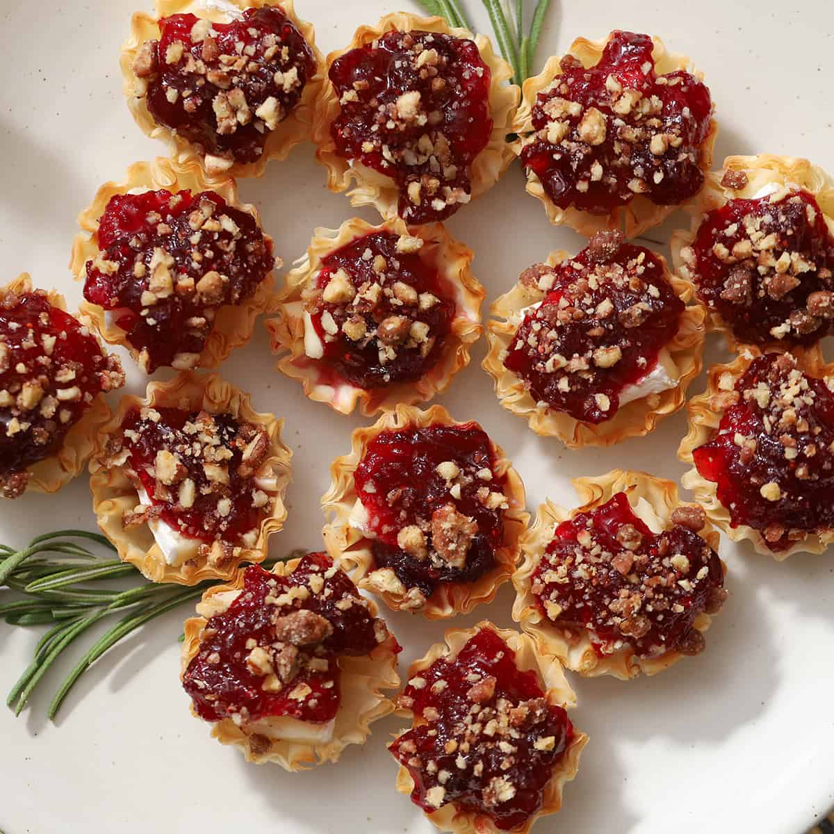 A plate of brie cheese and cranberry bites.