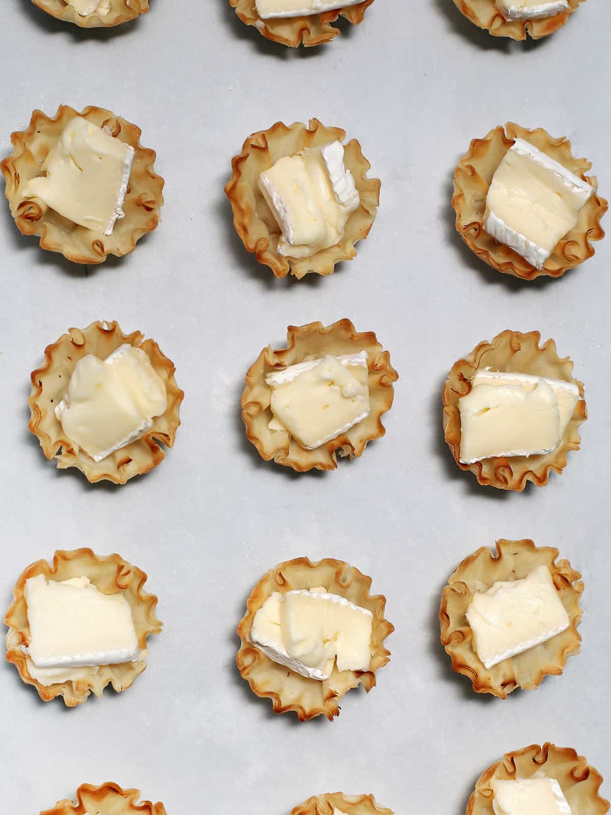 Brie cheese pieces in phyllo cups .