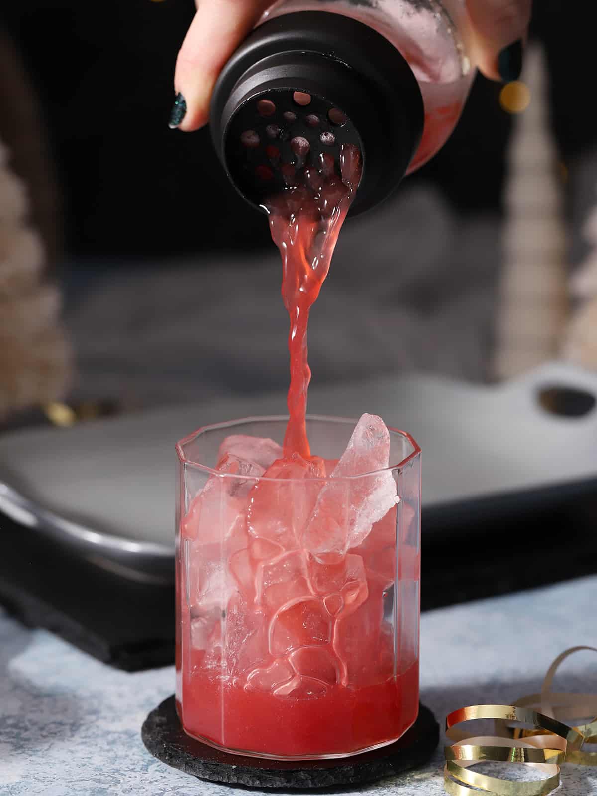 Cherry mocktail being poured into a glass. 
