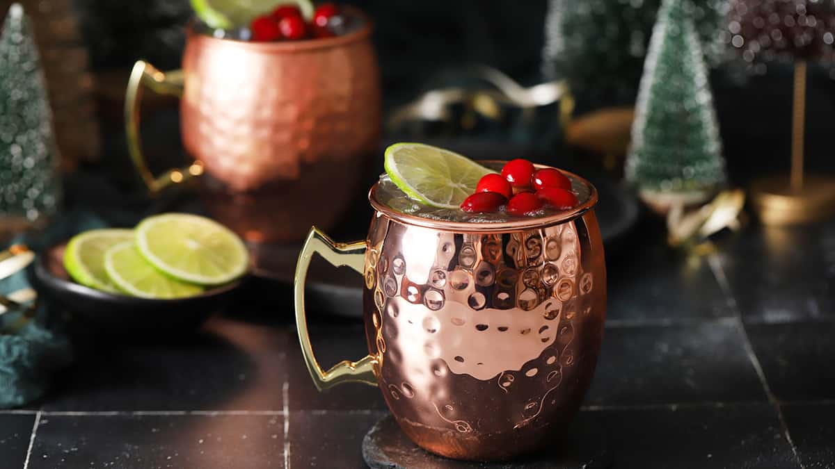 Copper mugs filled with cranberry moscow mule cocktail. 