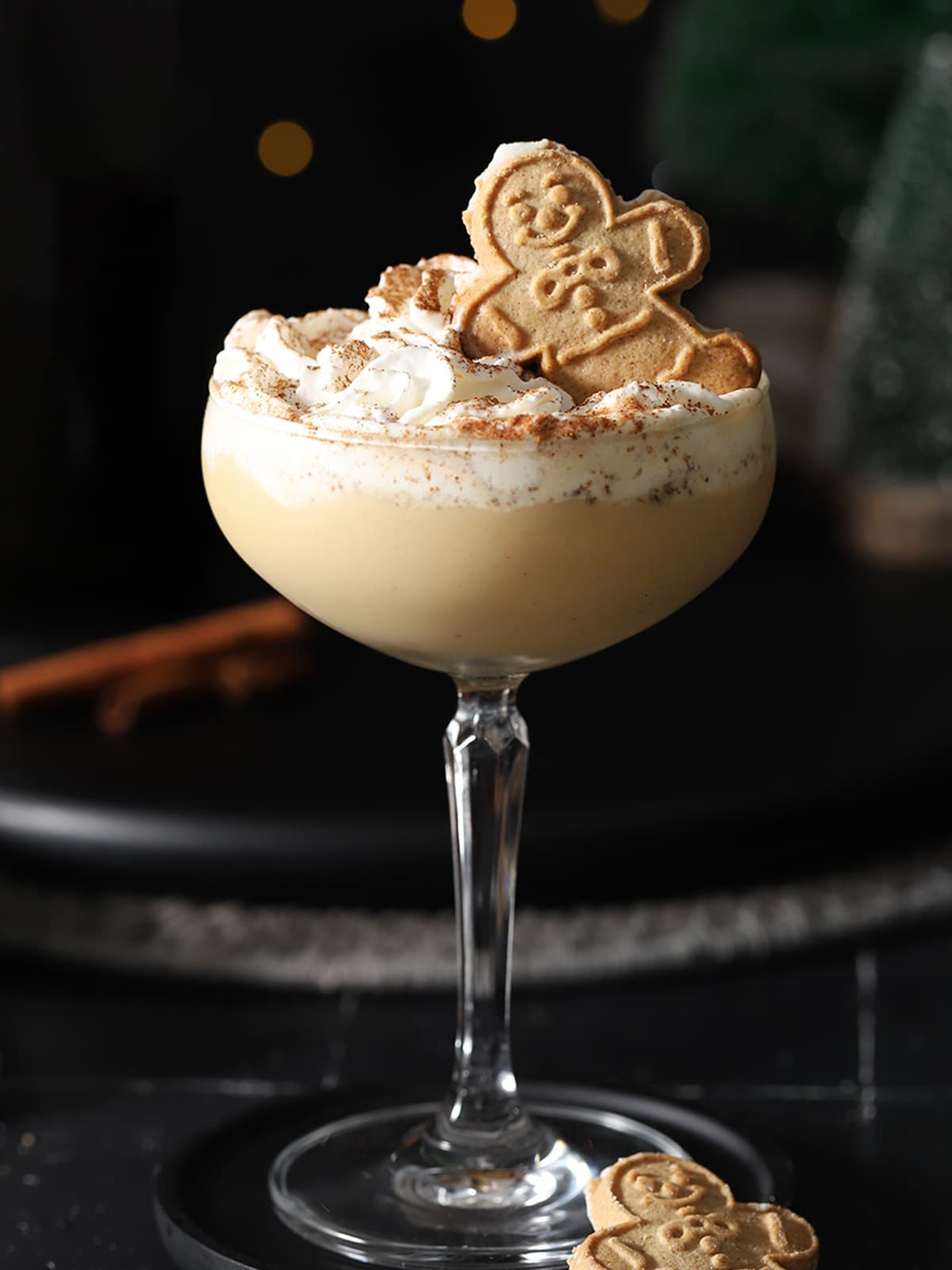 A gingerbread martini topped with whipped cream and a gingerbread cookie.