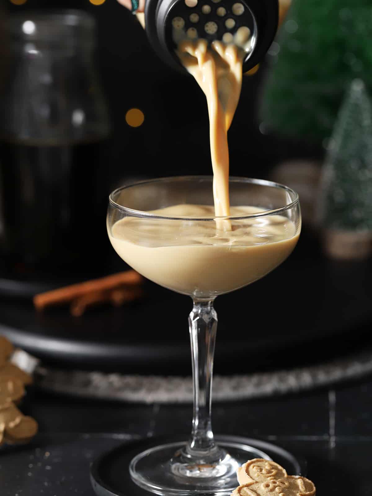 Gingerbread martini cocktail being poured into a coupe glass. 