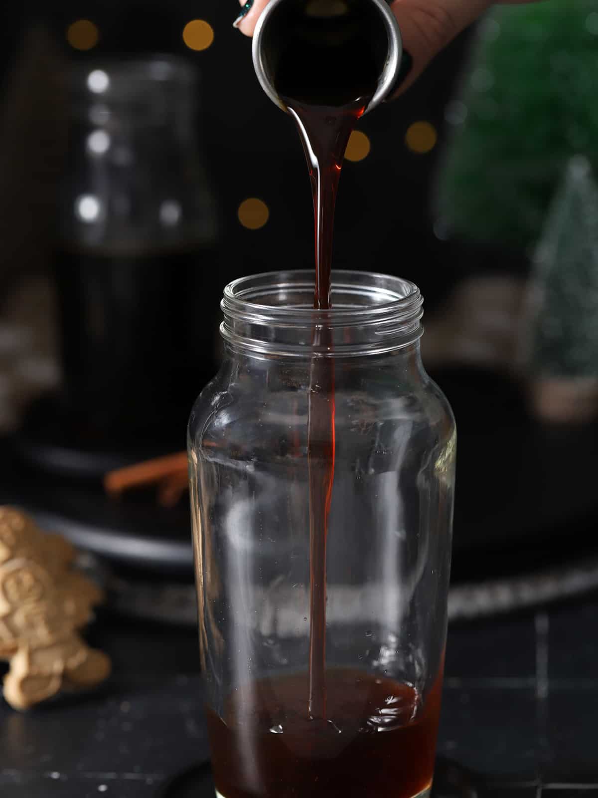 Gingerbread syrup being poured into a cocktail shaker. 