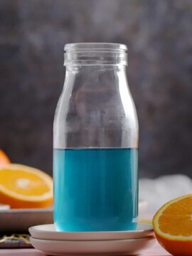 A glass bottle filled with blue Curaçao syrup.