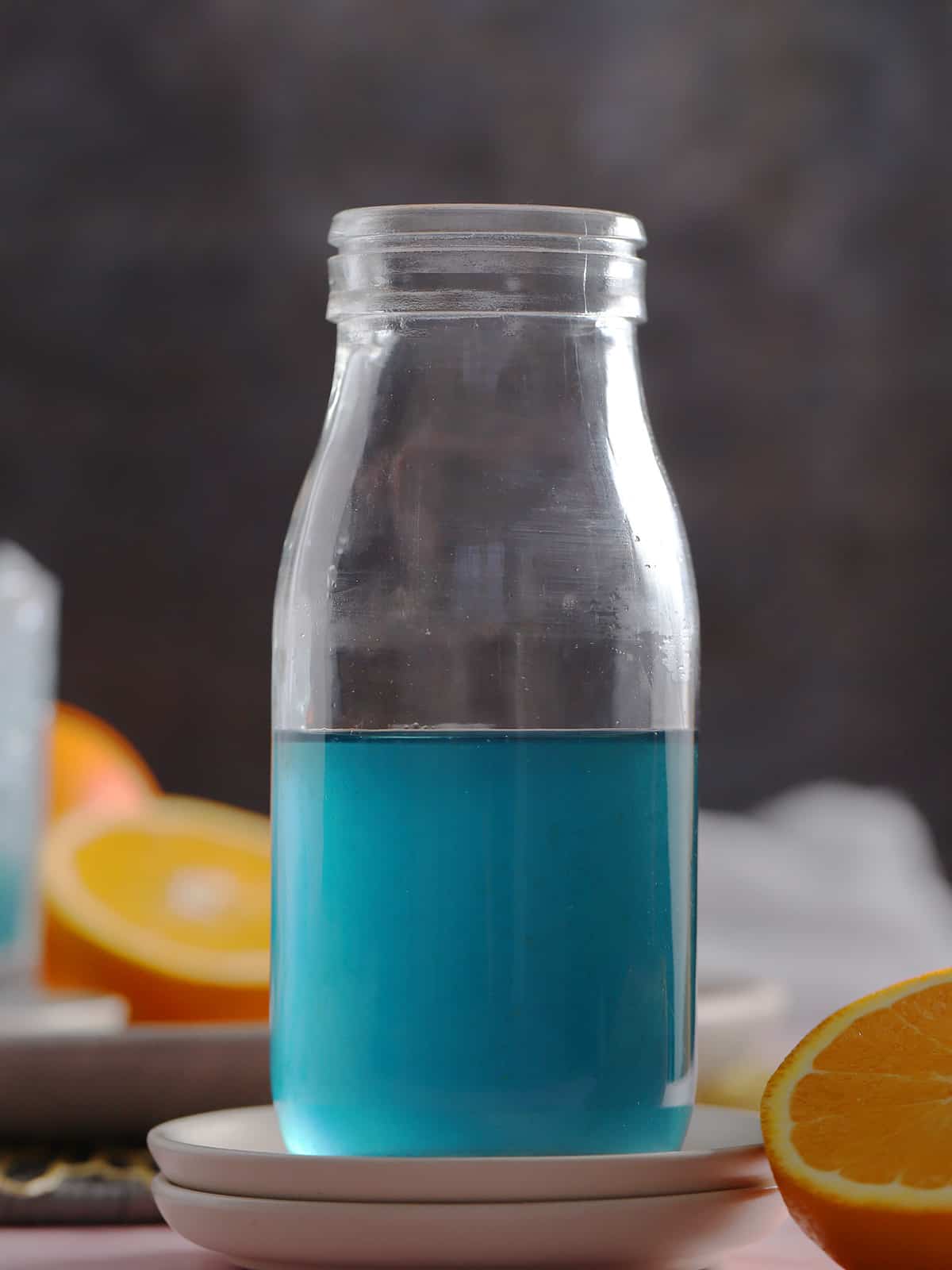 A glass bottle filled with blue Curaçao syrup.