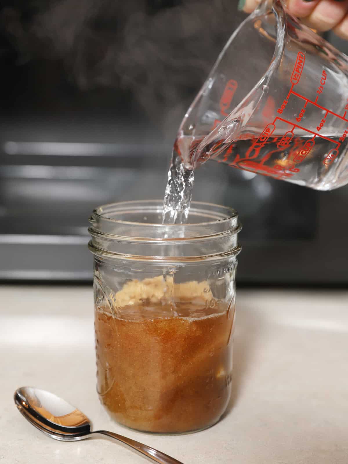 Hot water being poured into a mason jar. 