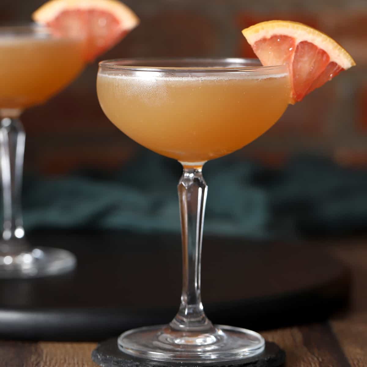 Glasses of brown derby cocktail garnished with grapefruit.