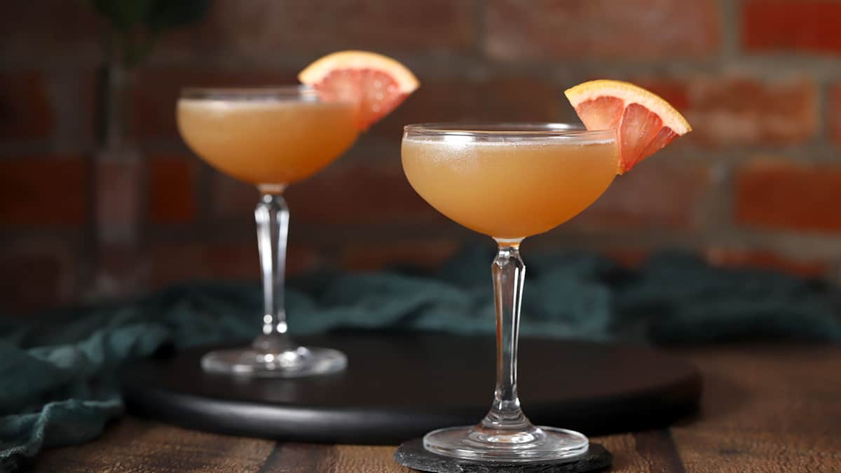 Glasses of brown derby cocktail garnished with grapefruit. 