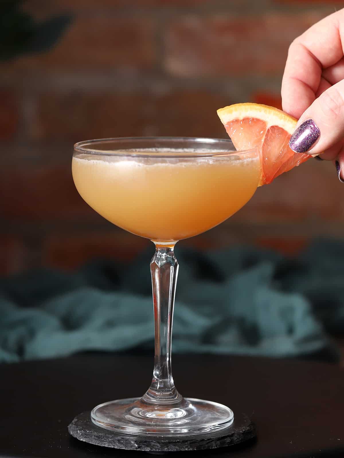 Glasses of brown derby cocktail garnished with grapefruit.