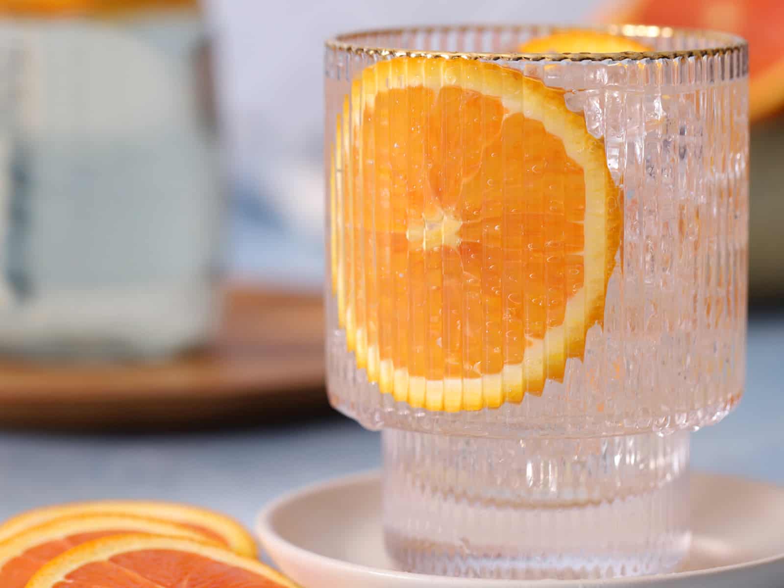 A glass of orange syrup and sparkling water. 