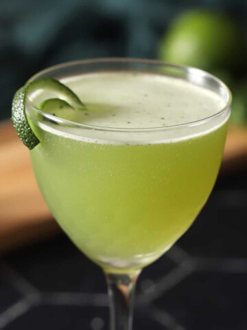 A glass of basil gimlet cocktail.