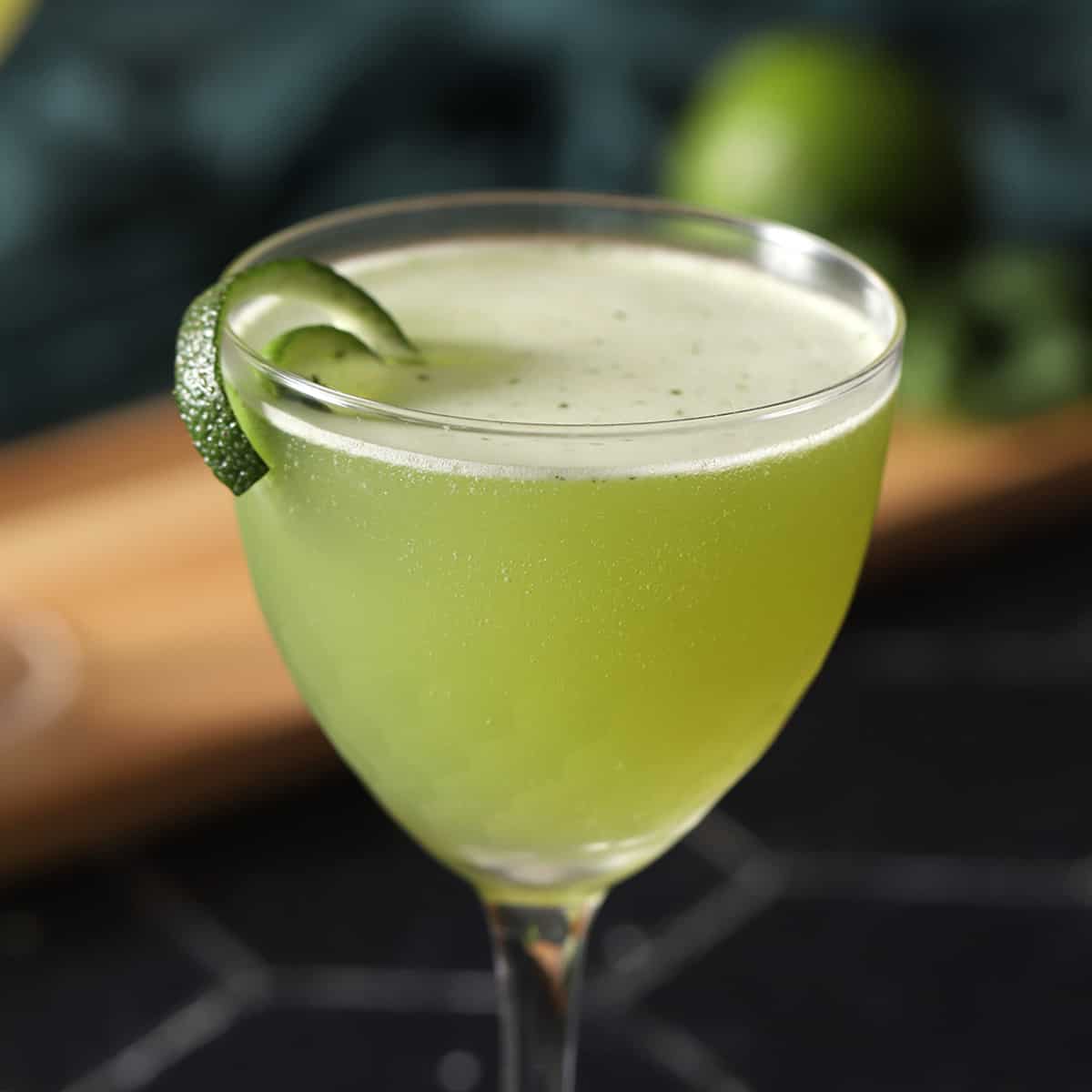 A glass of basil gimlet cocktail.