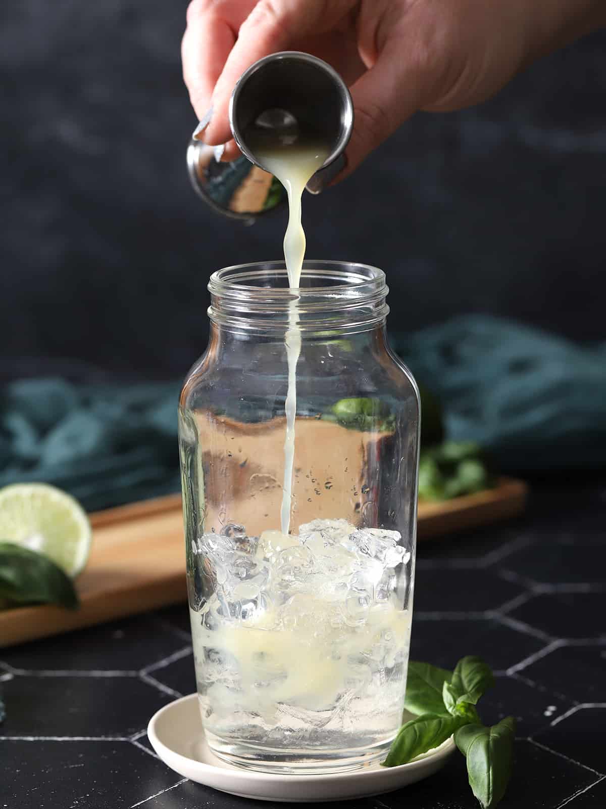 Lime juice being poured into a cocktail shaker. 