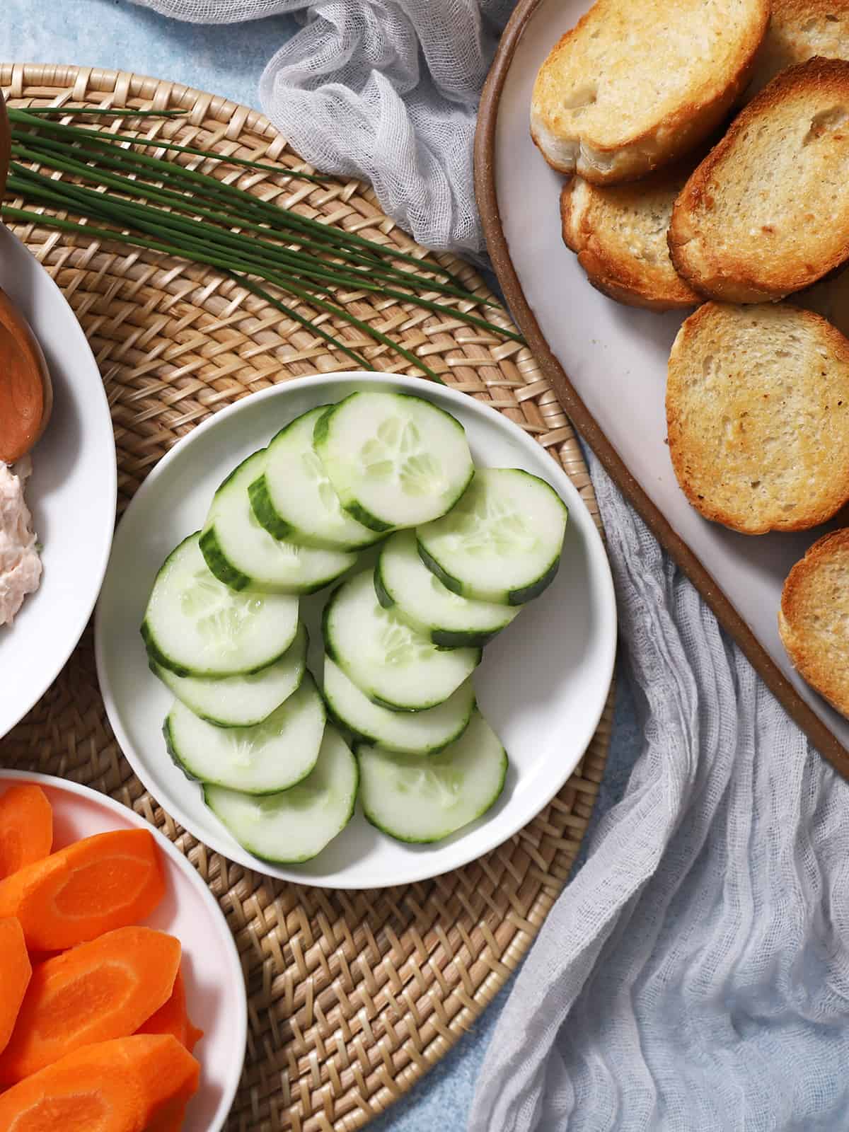 A plate of carrot slices, cucumber slices, and bread slices. 