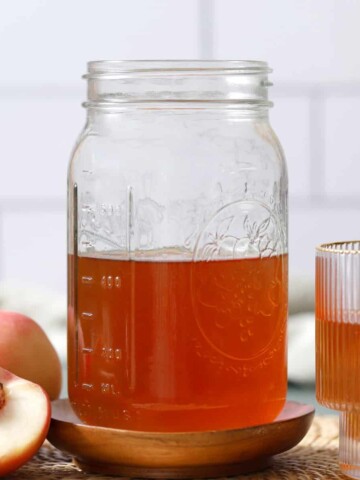 A jar filled with peach infused bourbon.