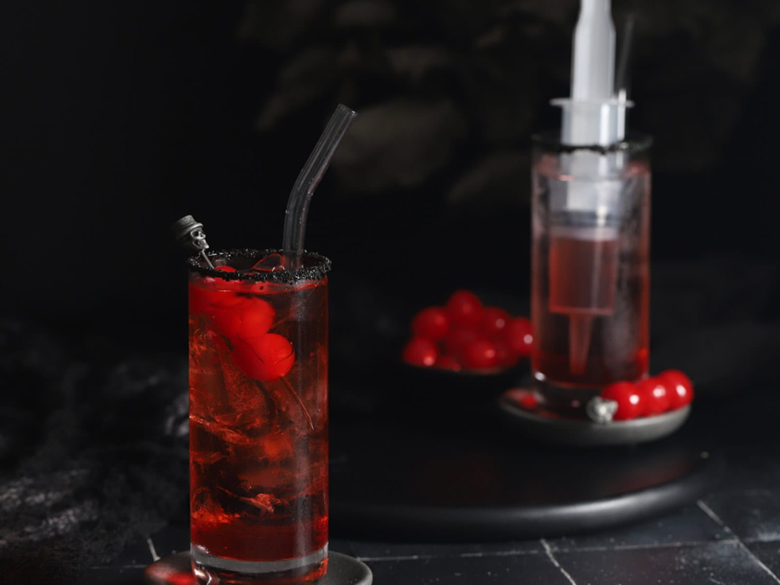 Glasses filled with lemon lime soda, ice, and syringes of grenadine syrup.