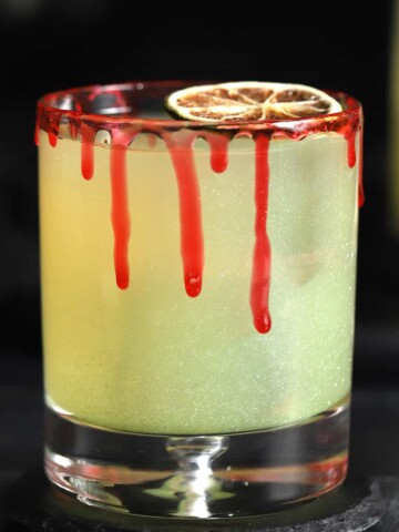 A glass of Halloween margarita with a bloody rim.