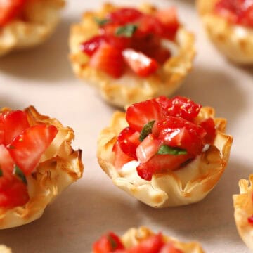 Looking down at a tray filled with Strawberry Bites with cream cheese.