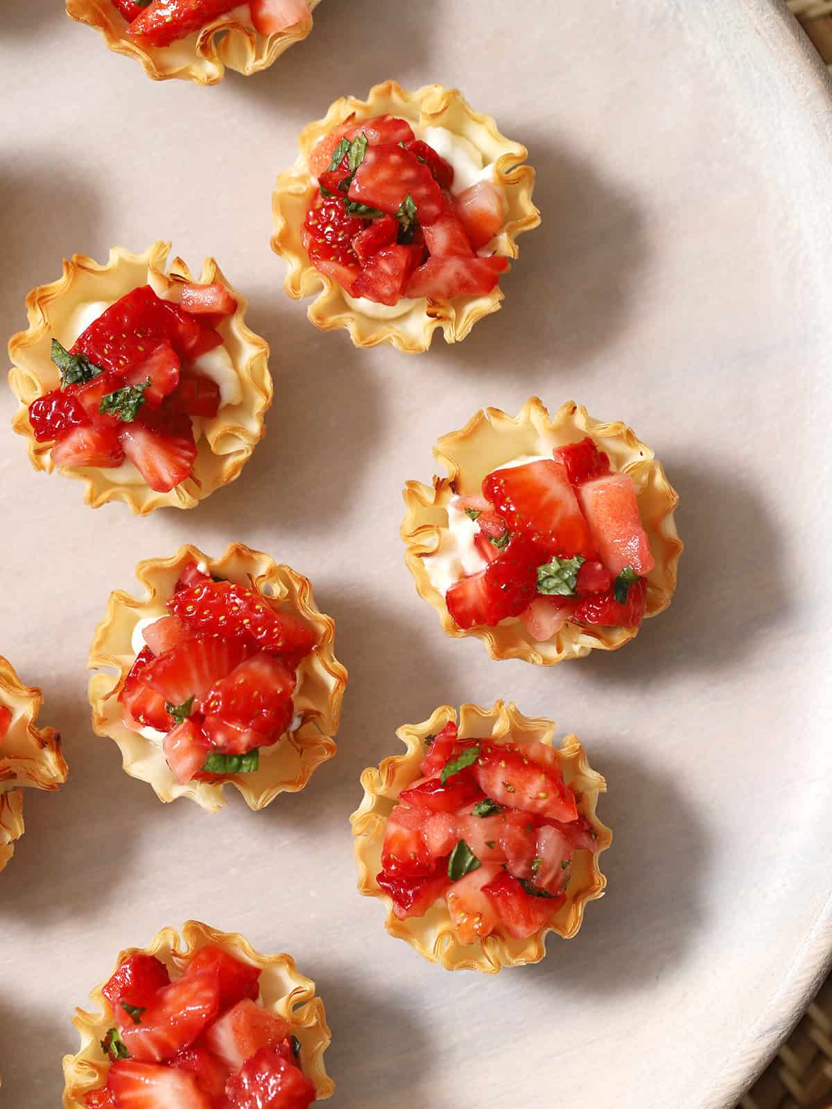 Looking down at a tray filled with Strawberry Bites with cream cheese.
