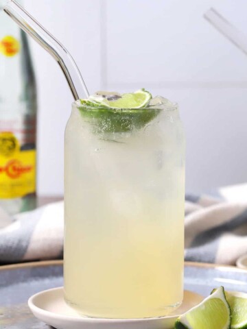 Glasses of ranch water surrounded by bottles of Topo Chico and fresh limes.