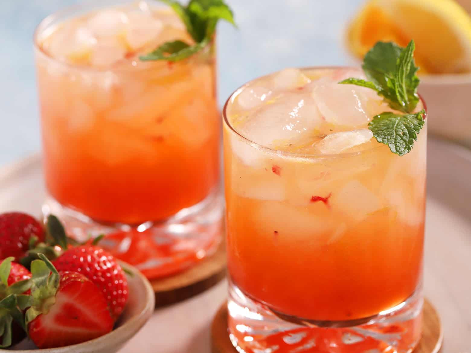 Glasses of bourbon smash cocktails garnished with mint.