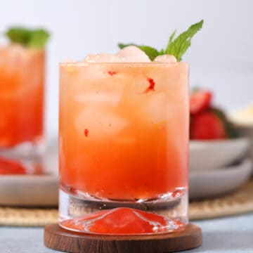Glasses of bourbon smash cocktails garnished with mint.