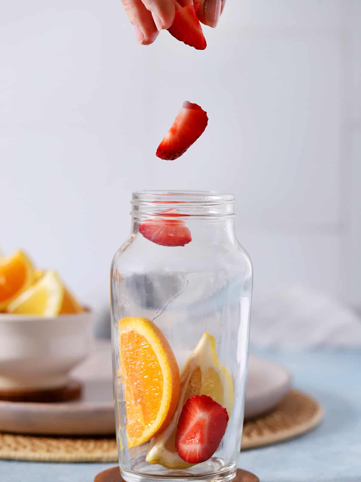Pieces of strawberries dropping into a cocktail shaker.