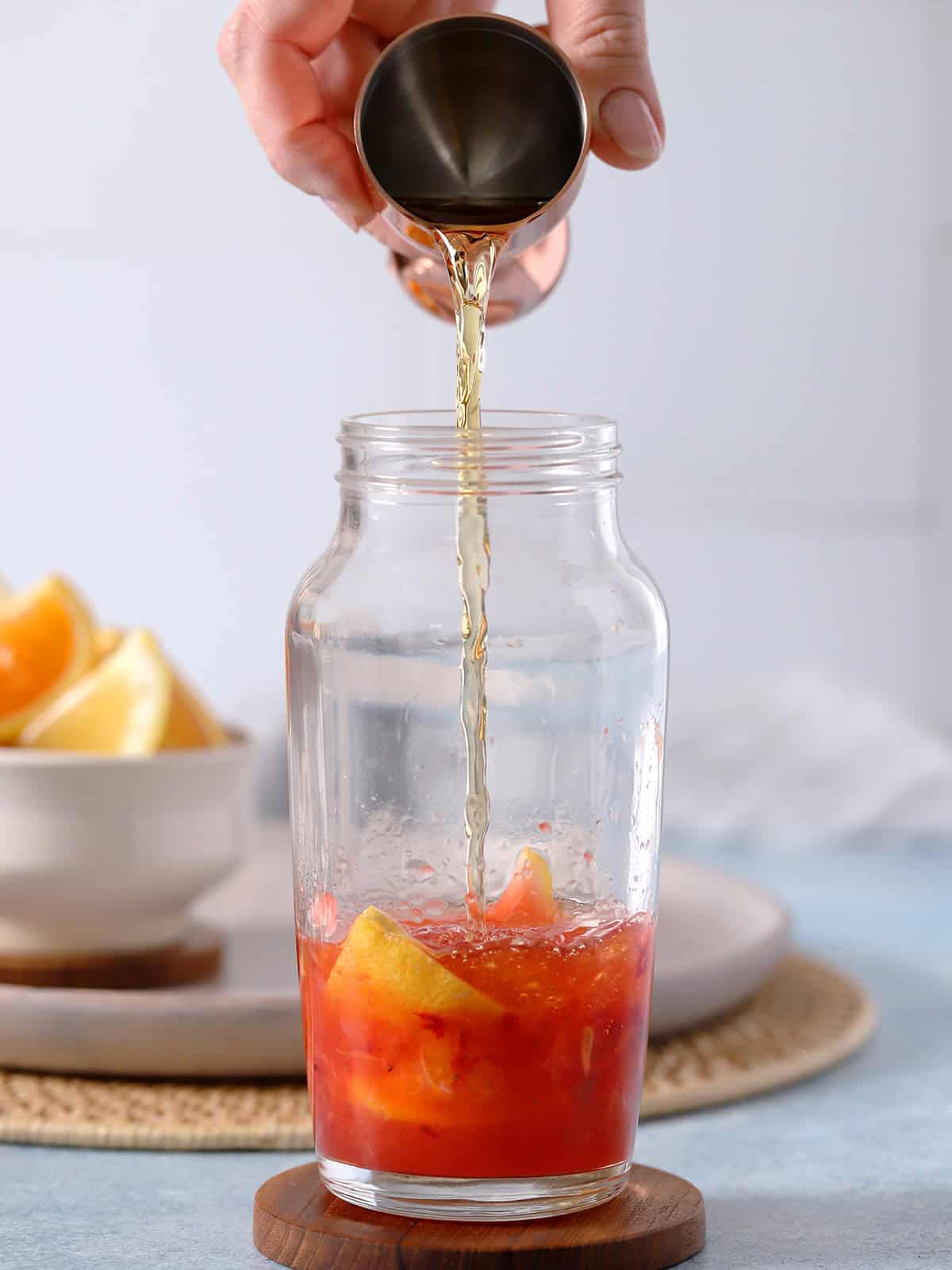 Bourbon being poured into a cocktail shaker.
