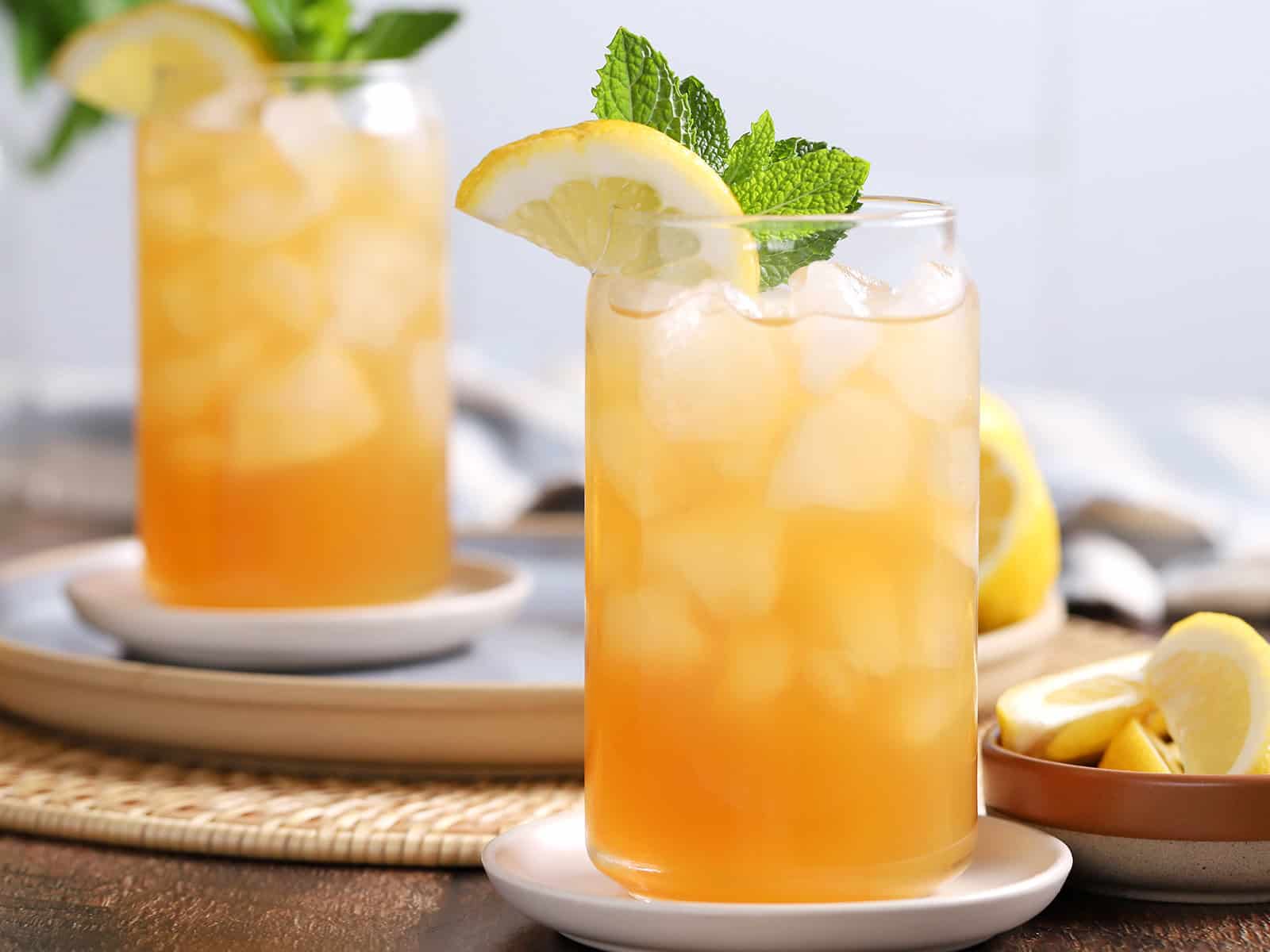 Glasses of Arnold Palmer drink garnished with lemon and mint.